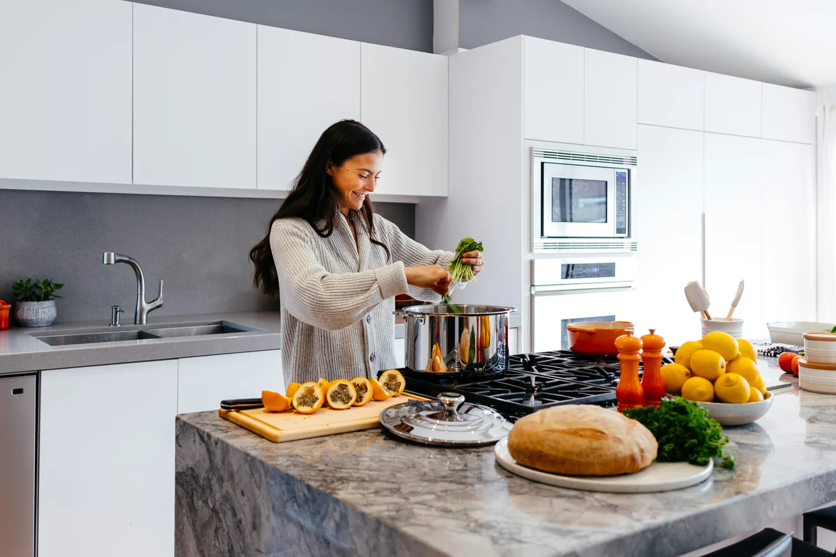 woman smiling while cooking - healthy lifestyle wellness - affordable air fryers for healthy family meals