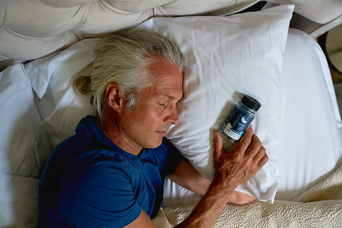 a man laying in bed holding a cell phone - healthy lifestyle wellness - affordable air fryers for healthy family meals