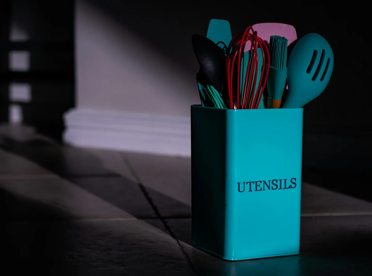 a blue utensil holder with utensils in it - affordable ecofriendly kitchen gadgets 2026