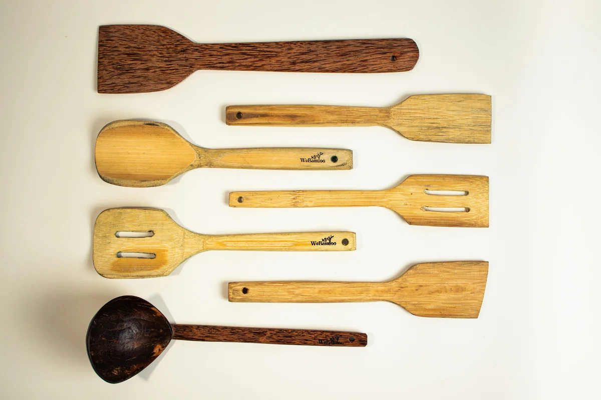 a group of wooden spoons and spatulas on a white surface - affordable ecofriendly kitchen gadgets 2026