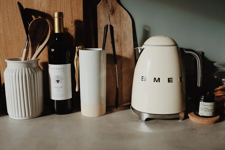 A modern kitchen setup featuring a Smeg kettle, wine bottle, and utensils for a stylish cooking space. - affordable electric kettles with temperature control