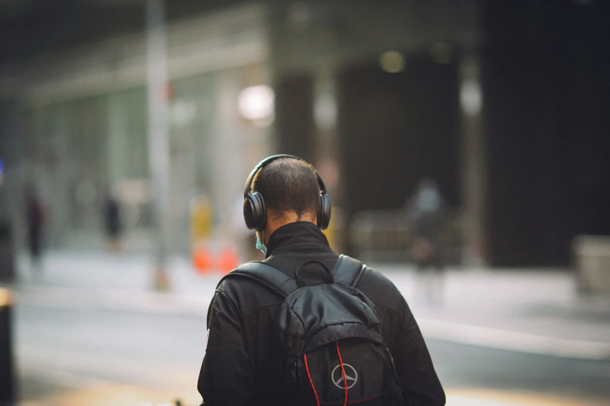 man in black jacket wearing black headphones - affordable noise cancelling headphones for commuting