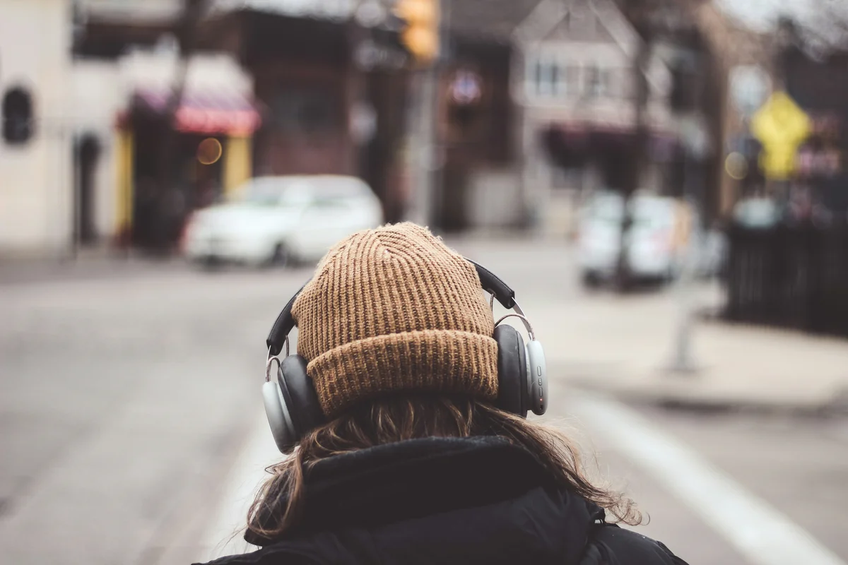 Girl listening to music  - affordable noise cancelling headphones for commuting