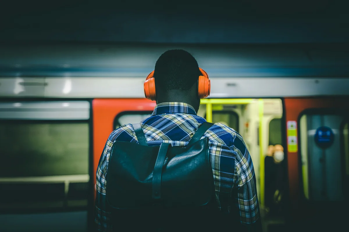 Dude with headphones down London metro - affordable noise cancelling headphones for commuting
