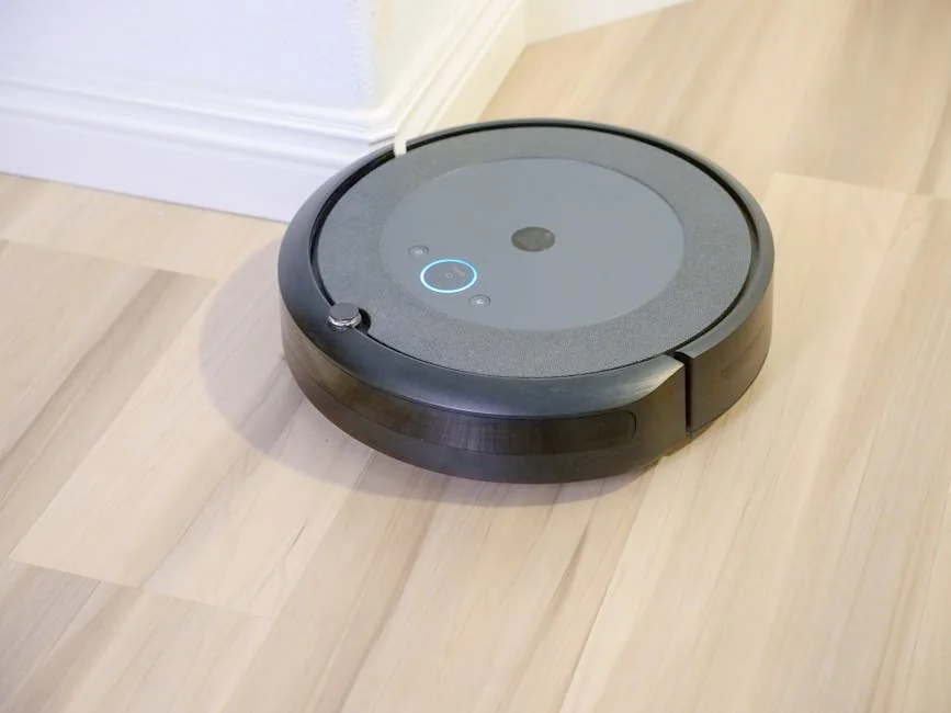 A sleek, modern robotic vacuum cleaner efficiently operating on a hardwood floor. - affordable robotic vacuums for hardwood floors