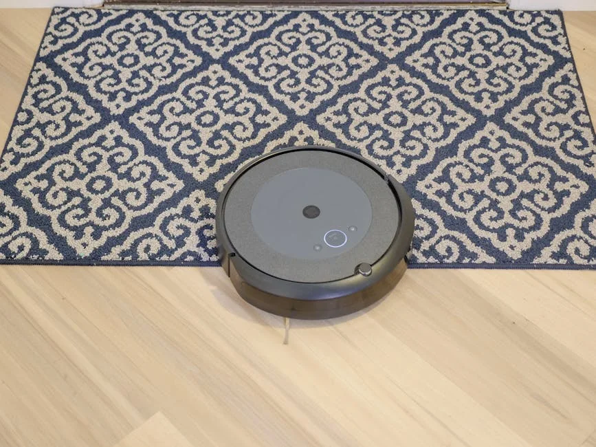 A modern robotic vacuum cleaning a stylish patterned carpet on a wooden floor. - affordable robotic vacuums for hardwood floors