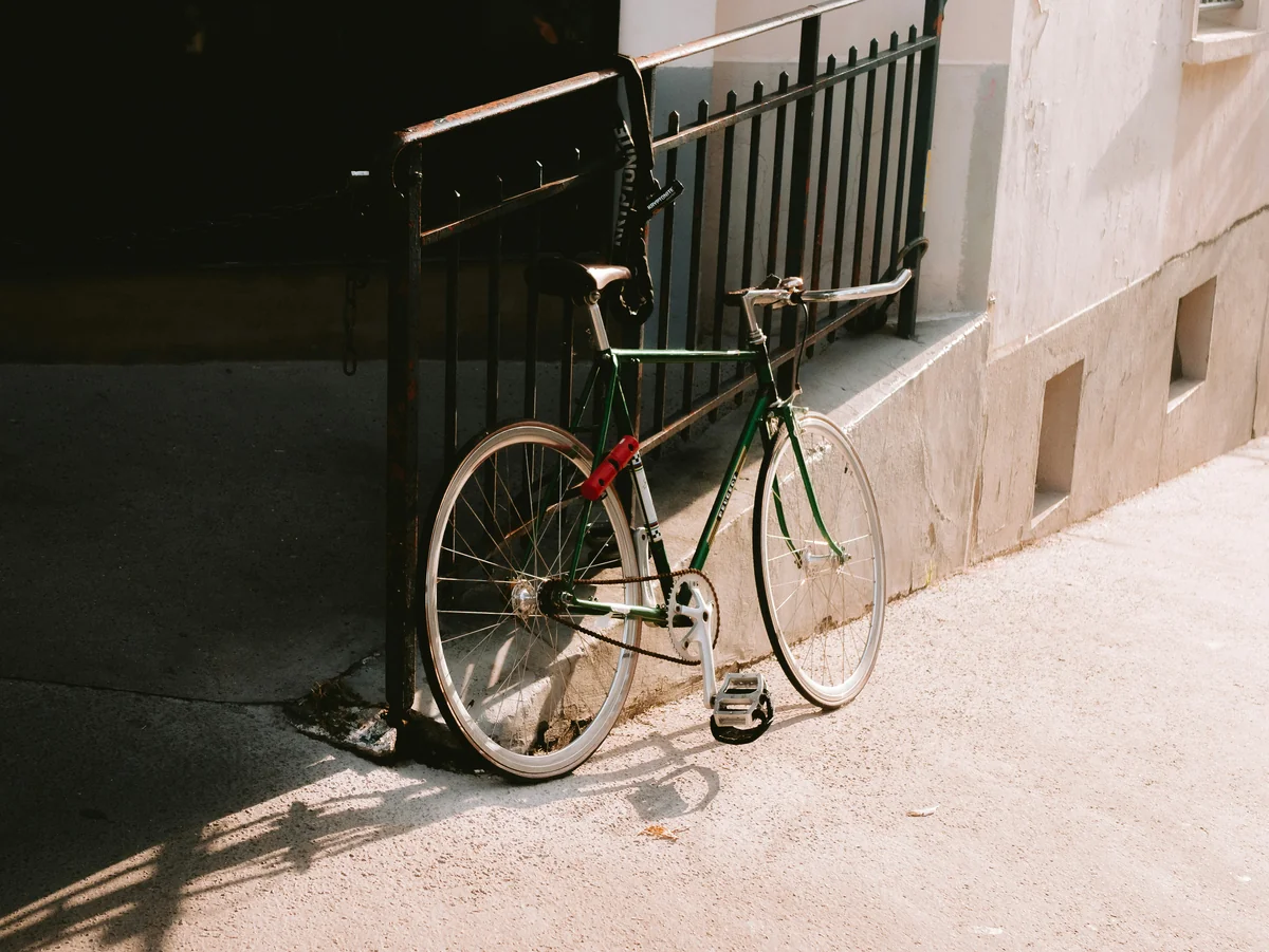 A bicycle leans against a wall in sunlight. - best bike locks for urban commuting