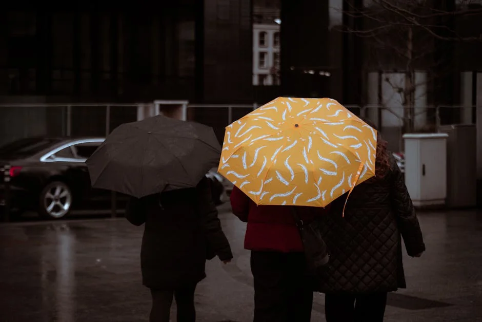 City dwellers with umbrellas walking in Dublin on a rainy day, showcasing street life energy. - best compact umbrellas for windy weather
