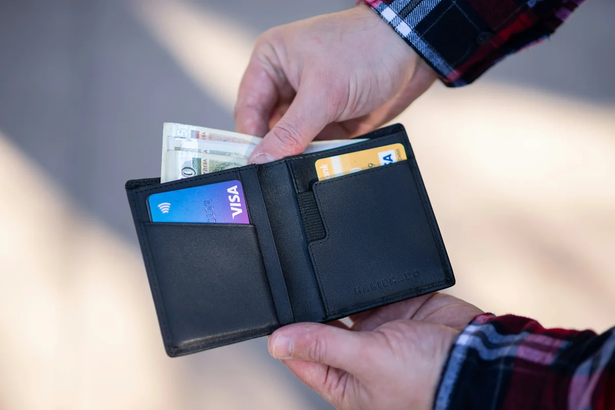 black leather bifold wallet on persons hand - best minimalist wallets for men with rfid blocking
