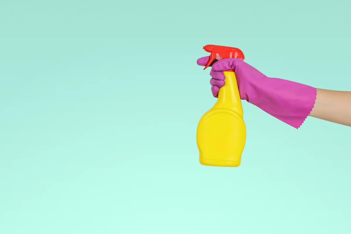 person holding yellow plastic spray bottle - best multipurpose cleaning sprays for kitchens