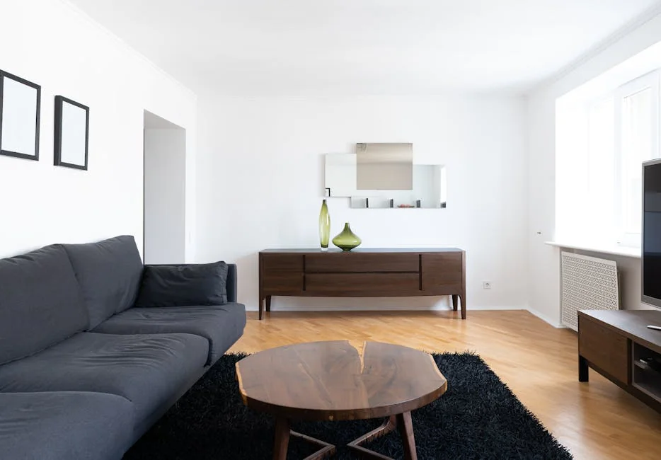 Interior of modern light home with couch near wooden table on carpet near cabinets with vases and TV - best product reviews for small apartments
