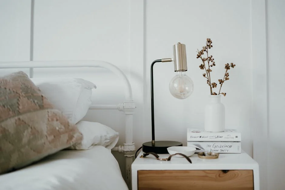 Stylish minimalist bedroom with a modern bedside table featuring a lamp, books, and decorative elements. - best reading lamps for bedside tables