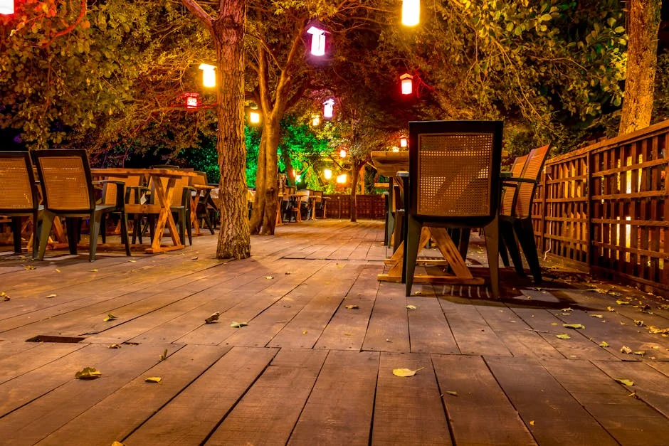Charming outdoor dining setup with wooden tables and hanging lights, creating a warm and inviting atmosphere at night. - best solar deck lights for outdoor security