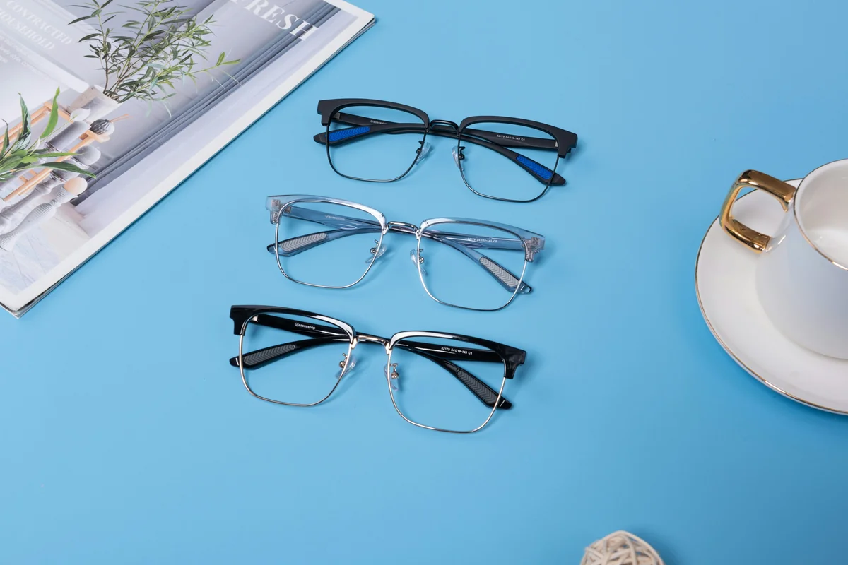 This image showcases three pairs of modern glasses arranged on a bright blue surface. Each pair features a unique frame design: a sleek black frame with blue accents, a transparent frame with a subtle blue hue, and a classic black frame with silver detailing. - most stylish blue light blocking glasses for work