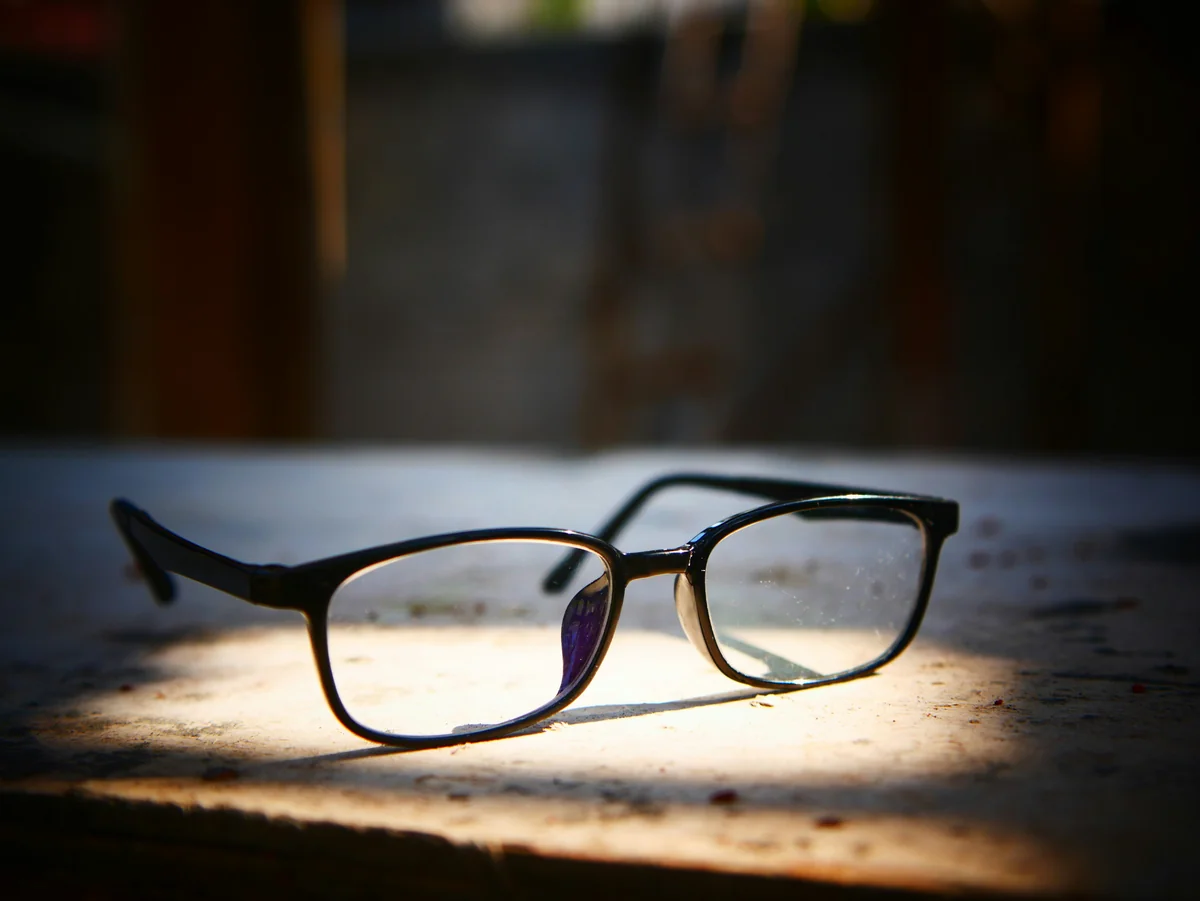 a pair of glasses sitting on top of a wooden table - most stylish blue light blocking glasses for work
