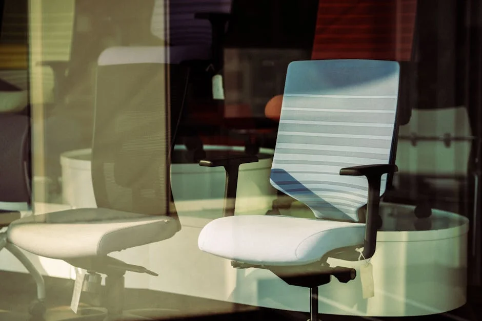 Contemporary office chairs displayed behind glass, offering modern ergonomic solutions for workspace. - top rated ergonomic office chairs for back pain