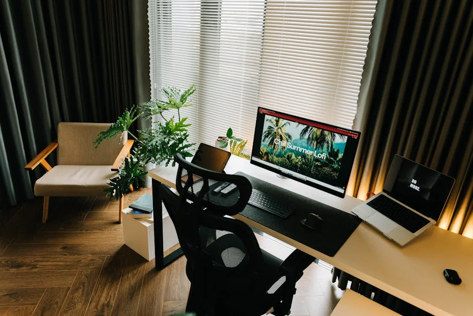 A stylish home office setup with a computer, laptop, and indoor plants by a window. - top rated ergonomic office chairs for back pain