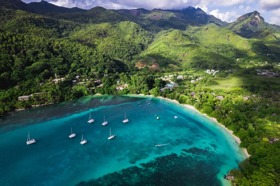 Stunning aerial shot of Beau Vallon Bay's turquoise waters, lush greenery, and anchored boats in Seychelles. - adventure vacation destination - top rated portable power banks for travel